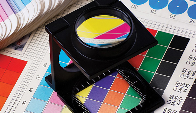 A folding loupe magnifier on a color swatch